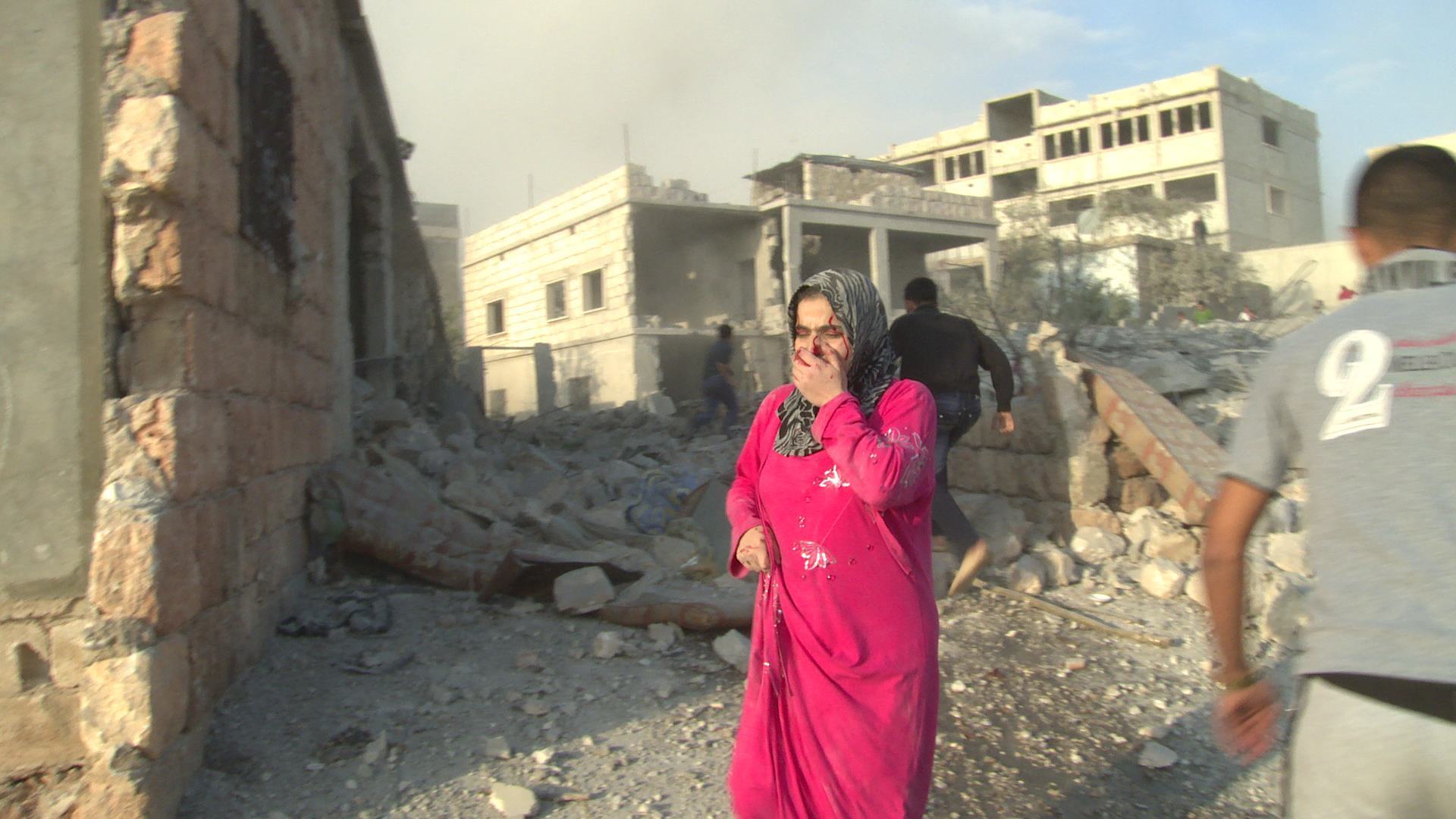 Families emerge from the rubble after an air strike in the Sunni village of Al Barra, October 2012  1